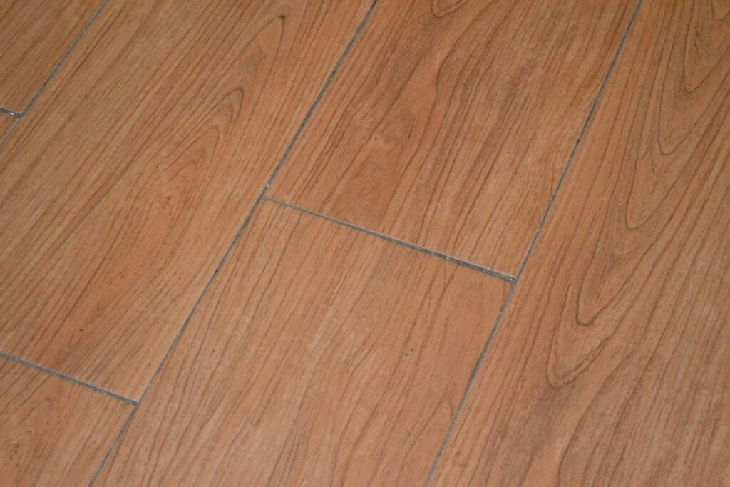 a close up of a wooden floor with a white cat laying on it